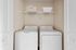 Convenient laundry room with modern washer and dryer, enhanced by smart storage in a cozy apartment space.