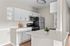 Sleek modern kitchen with pristine countertops, elegant white cabinetry, and stainless steel appliances.