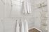 Spacious walk-in closet featuring organized shelving, hanging space, and neatly stacked storage boxes, perfect for stylish living.