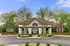 Charming residential property with elegant entrance, surrounded by lush greenery and well-manicured shrubs.
