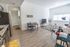 University Pointe, interior, living room, gray leather sofa, black and white area rug, tv, coffee table, kitchen, wood floor, dark cabinets, stainless steel appliances, stove/oven, dishwasher, refrigerator, window, dining table for two