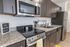 University Pointe, interior, kitchen, wood floor, dark cabinets, stainless steel appliances, stove/oven, dishwasher, refrigerator, lemon floor mat,