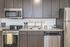 University Pointe, interior, kitchen, wood floor, dark cabinets, stainless steel appliances, stove/oven, dishwasher, refrigerator, lemon floor mat, 'home' 'bon appetit'