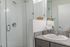 University Pointe, interior, bathroom, spacious glass door shower stall, dark cabinet, mirror