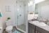 University Pointe, interior, bathroom, spacious glass door shower stall, toilet, tile floor, teal accents, dark cabinet, mirror