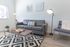 University Pointe, interior, living room, gray leather sofa, black and white area rug, coffee table, window, chair
