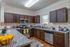 Model apartment kitchen with brown cabinets and stainless steel appliances