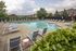 Community pool with plenty sun loungers all facing the pool