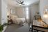 Model apartment bedroom with gray carpets, light gray walls and a large window