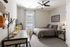 Model apartment bedroom with gray carpet, light gray walls, and a large window