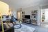 Model apartment living room with gray hardwood style flooring and light gray walls