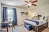 Model bedroom at our apartments for rent in Louisville, KY, featuring carpeted flooring and windows with blinds.