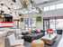 Community clubhouse with comfortable seating, a ping pong table, and large windows looking out at the pool.