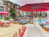 The pool area at our apartments in Tuscaloosa, featuring red pool chairs, umbrellas, and a clubhouse.