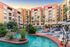 Lazy river with sun loungers and the apartments in the background overlooking the pool deck