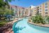 lazy river wrapping around greenery and apartments in the background overlooking the pool deck