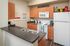 Model kitchen at our student housing in Orlando, featuring wood grain floor paneling and stainless steel appliances.