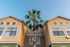 The exterior of our student living apartments in Orlando, FL, featuring a view of the stucco facades and apartment windows.