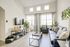 Model living room at our student living apartments in Orlando, featuring a couch, desk, and carpeted flooring.