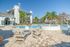 The pool lounge at our apartments for rent in Orlando, Florida, featuring beach chairs, umbrellas, and ping pong table.