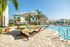The pool lounge at our apartments for rent in Orlando, Florida, featuring beach chairs, umbrellas, and ping pong table.