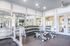 The fitness center at our apartments for rent near Penn State, featuring treadmills, exercise bikes, and ceiling fans.