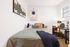 Model bedroom at our student apartments for rent near Penn State, featuring a desk and grey bedspread.