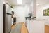Model kitchen at our apartments near Penn State, featuring wood grain floor paneling and granite patterned countertops.