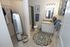 Chic bathroom with modern sink, delightful floral rug, and cozy corner shower, complemented by a stylish full-length mirror and thoughtful decor.