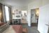 Charming bedroom view with cozy decor, artistic wall gallery, and a glimpse into the modern bathroom and inviting kitchen.