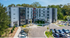 Contemporary apartment complex with sleek architecture, ample parking, and lush greenery, offering modern living in a vibrant area.