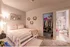Cozy bedroom with elegant decor, warm lighting, and a spacious walk-in closet leading to an ensuite bathroom.