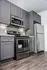 Modern kitchen with sleek gray cabinetry, stainless steel appliances, and granite countertops.
