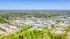 Vibrant aerial view of a lush suburban area with modern buildings surrounded by greenery, perfect for tranquil living.