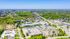 Scenic aerial view of a vibrant suburban area featuring lush green spaces, modern apartment buildings, and well-laid-out streets.