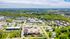 Aerial view of a vibrant community featuring lush greenery, modern apartment buildings, and an inviting neighborhood layout.