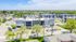 Charming aerial view of modern apartment complex surrounded by lush greenery and vibrant neighborhoods, offering a serene and inviting atmosphere.