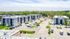 Modern apartment complex featuring spacious units with balconies, ample parking, and lush green surroundings.