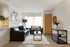 Contemporary living room with sleek leather sofas, stylish decor, and large windows offering abundant natural light.