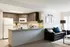 Modern open-concept kitchen and living area featuring sleek dark cabinetry, granite countertops, and stylish decor.