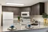 Modern kitchen with sleek dark cabinets, granite countertops, and contemporary appliances, perfect for culinary enthusiasts.