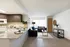 Modern open-concept living area with a stylish kitchen featuring granite countertops, sleek dark wood cabinets, and abundant natural light.