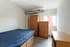 Cozy bedroom featuring stylish wooden furniture, spacious wardrobe, and ample natural light.