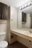 Modern bathroom featuring elegant lighting, sleek cabinetry, and a spacious countertop with built-in sink.