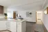 Modern apartment interior with a stylish open kitchen featuring granite countertops, chic decor, and bright living space.