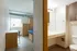 Bright apartment bedroom with modern wooden furnishings and adjacent bathroom.