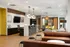 Contemporary communal area with stylish seating, sleek wood flooring, and chic hanging lights, ideal for social gatherings or relaxed work sessions.