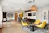 Modern lobby area featuring vibrant yellow chairs, stylish lighting, and a sleek seating arrangement with a contemporary design aesthetic.