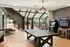 Stylish recreational lounge with ping pong table, arcade games, and cozy seating area under skylights.