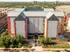 Modern apartment complex with vibrant fa&ccedil;ade and lush landscaping, offering urban living with scenic views and ample green space.